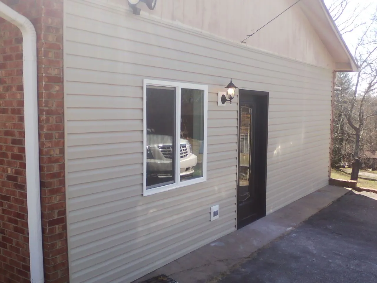 New vinyl siding and entry door on a room addition in Clinton